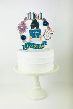 a white cake topped with an image of a woman holding a book on top of it