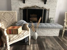 a living room filled with furniture and a fire place in front of a brick fireplace