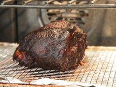 a piece of meat sitting on top of a grill next to an open oven door