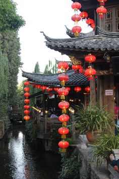 red lanterns hanging from the roof over a river