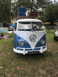 a blue and white vw bus parked in the grass