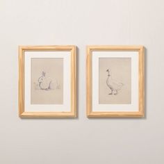 two framed drawings on the wall next to each other, one with a duck and another with a rabbit