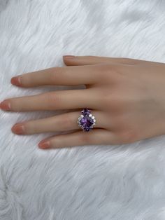 The key stone of this ring is a 11x9mm natural amethysts, and the main material of this ring is sterling silver plated with 18k white gold. On each side of the main stone are one 5x3mm and two 5x2.5mm amethysts. The small accent stones and zircon emphasize the big size of the key stone. Amethyst is a birthstone for February, and the color purple is meant to bring wealth and royalty. Also, many people believe amethyst has the power to relieve stress and purify the mind. Size: Adjustable and fitab Fine Jewelry Pear-shaped Crystal Promise Ring, Pear-shaped Crystal Ring For Promise, Fine Jewelry, Pear-shaped Fine Jewelry Crystal Promise Ring, Pear-shaped Crystal Ring For Promise, White Gold Crystal Ring With Gemstone, Anniversary Rings With Accent Stones And Open Design, Fine Jewelry Pear-shaped Crystal Ring For Anniversary, Cubic Zirconia Gemstone Ring For Promise, Fine Jewelry Crystal Open Ring For Anniversary