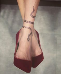 a woman's foot with a tattoo on her left leg and a snake in the middle