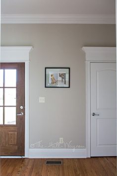 an empty room with two doors and a framed photo on the wall next to it