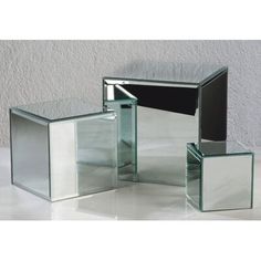 three glass tables sitting on top of a white floor