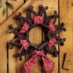 a wreath with red and white bows hanging on a wooden wall