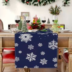 a blue box with white snowflakes on it sitting at a table in front of christmas decorations