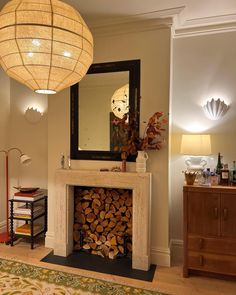 a living room filled with furniture and a fire place next to a mirror on the wall