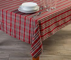 a red and white table cloth with plaid design on it is set for two people