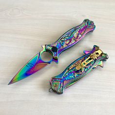 two multicolored knifes sitting next to each other on a table