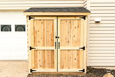 a wooden storage shed sitting in front of a garage