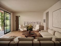 a living room with couches, chairs and a coffee table in front of a sliding glass door