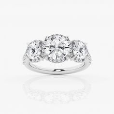 three stone engagement ring with diamonds on the sides and an oval center diamond in the middle