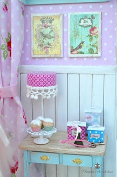 a table with cupcakes on it in a dollhouse