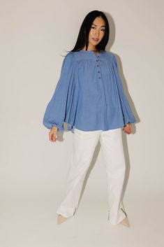 this retro-inspired long sleeve top will take you from summer picnics to fall photoshoots with ease. made with a dark wash denim-esque material, this elevated top features long balloon sleeves + a flowy silhouette. dress it up with trousers + heels, or down with white jeans + sandals. medium wash // high neckline, buttons, balloon sleeves, elastic cuffs paired with our camelot wide leg denim model is 5'8" + wearing a small measurements are approximate + taken while laying flat small : bust 42” l Flowy Peasant Top With Puff Sleeves For Fall, Flowy Tops With Elastic Sleeves For Fall, Flowy Top With Gathered Sleeves For Fall, Fall Peasant Top With Blouson Sleeves And Flowy Fit, Fall Peasant Top With Blouson Sleeves, Denim Blue Cotton Blouse For Day Out, Cotton Top With Lantern Sleeves For Fall, Fall Cotton Top With Lantern Sleeves, Fall Brunch Tops With Elastic Sleeves