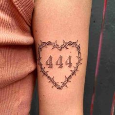 a heart shaped tattoo with the number forty on it's arm and barbed wire