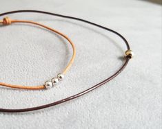 Simple minimalist leather cord bracelet - available in various designs with sterling silver, gold filled and rose gold filled beads. The sterling silver and gold filled beads are 3 mm and 4 mm in diameter each, rose gold beads are 3 mm in diameter each. The bracelet is adjustable with sliding knots and is available in 3 colours: black, brown and tan. The cord is made of genuine leather, 1 mm thick. These bracelets are lovingly handmade and would make a wonderful gift for a man, woman or child. C Leather Cord Bracelets, Rose Gold Beads, Bracelet Leather, Cord Bracelet, Cord Bracelets, Braided Bracelets, Gold Beads, Leather Cord, Silver Beads