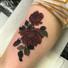 a close up of a person's arm with a flower tattoo design on it