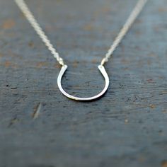 Hand-forged and hammered, this horseshoe of sterling silver has a nice size and a pretty finish for a lifetime of wear and love... and good luck! It is hung from a sterling silver chain and lends itself nicely to both dressing up and everyday wear. The horseshoe pendant measures approximately one inch long. Each horseshoe is handcrafted individually, so you can expect some slight variation from the piece pictured. Choose your necklace length from the drop-down menu. ONE WEEK PROCESSING TIME: All Horseshoe Shaped Sterling Silver Necklaces, Silver Sterling Silver Horseshoe Necklace, Nickel-free Horseshoe Sterling Silver Jewelry, Classic Sterling Silver Horseshoe Jewelry, Classic Horseshoe-shaped Sterling Silver Jewelry, Good Luck Horseshoe, Good Luck Necklace, Horseshoe Pendant, Equestrian Jewelry