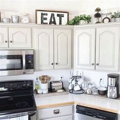 a kitchen with white cabinets and black appliances