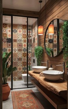 a bathroom with two sinks and a large mirror on the wall next to a potted plant