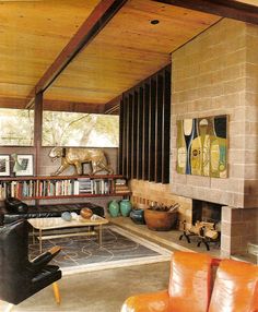 a living room filled with lots of furniture and a fire place in the middle of it