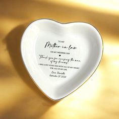 a heart shaped dish with a poem written on the side in black ink, against a yellow background