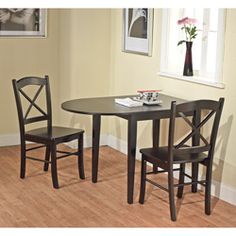 a small table and two chairs are in the corner of a room with hardwood floors