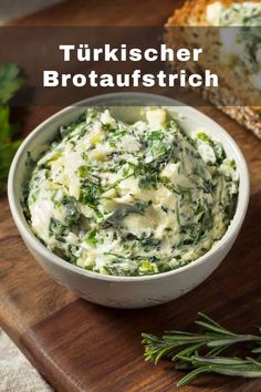 a white bowl filled with spinach and cheese on top of a wooden cutting board