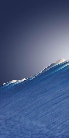 a man riding skis on top of a snow covered slope under a blue sky