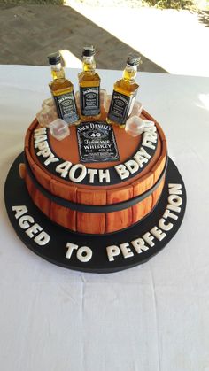 a birthday cake made to look like a barrel with whiskey bottles on the top and bottom