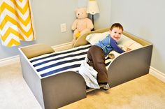 a young boy laying on top of a bed