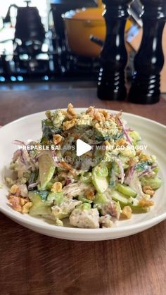 a white plate topped with salad on top of a wooden table