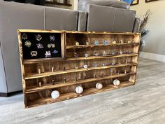 a display case with baseballs and pins on it in a living room next to a couch