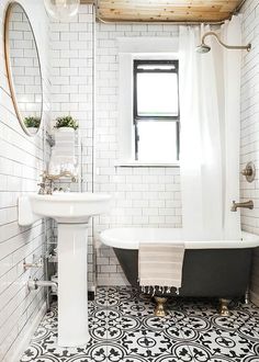 a bathroom with black and white tile flooring and a bathtub in the corner