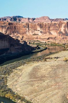 a river running through a desert landscape with mountains in the background