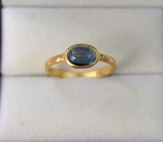 a gold ring with a blue stone in it