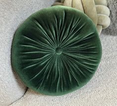 a green round pillow sitting on top of a white couch