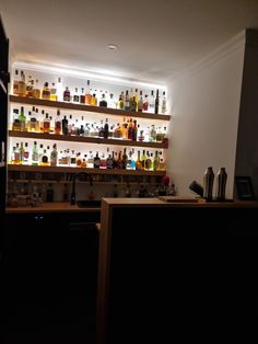 a dimly lit bar with liquor bottles on the shelves