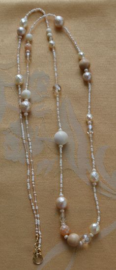 "Pretty vintage neutral plastic and glass beaded necklace is beige, white and champagne in color. The necklace is long and measures 42\" in length. It is in very good vintage condition and has a lobster claw clasp." Elegant White Double Strand Long Necklace, Elegant White Multi-strand Long Necklace, Elegant White Long Necklace With Round Beads, Elegant Cream Double Strand Necklaces, White Pearl Beaded Long Necklace, Elegant Double Strand Cream Necklace, Elegant Cream Double Strand Necklace, White Pearl Long Beaded Necklace, White Long Chain Necklace