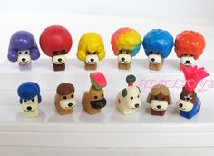 there are many small toy animals with different colors on their heads and faces, all in the same row