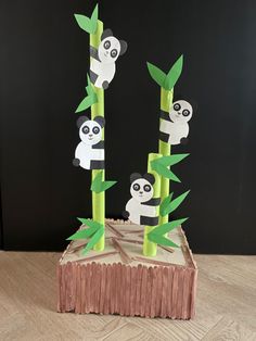 paper cut out of bamboo with pandas in the trees on it, sitting on a wooden block