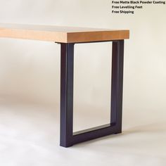 a wooden table with black metal legs and a white background that has the words free matte black powder coating on it