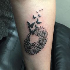 a black and white photo of a finger print with butterflies on it's arm