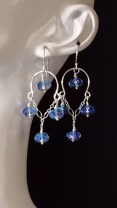 a pair of earrings with blue beads hanging from them