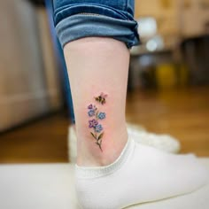 a small flower tattoo on the ankle