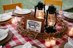 the table is set with candles, plates, and framed pictures on wicker baskets