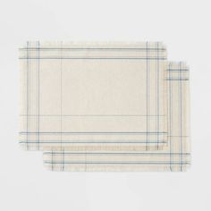 two placemats on top of each other in white and blue checkered fabric