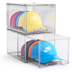 two clear acrylic bins with hats in them and one holding a cap